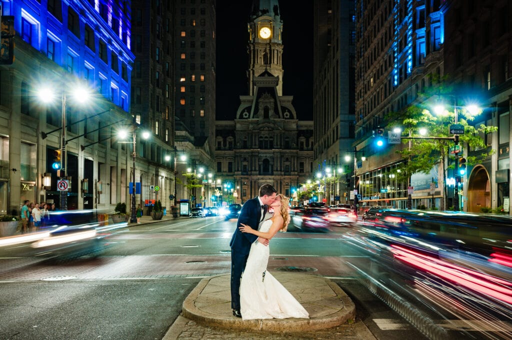 bride and groom kissing in the middle of the street at night