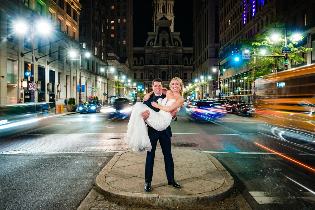 groom carries the bride in the middle of the street