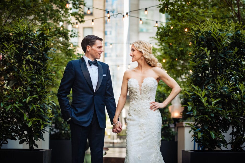 bride and groom looking at each other while holding hands