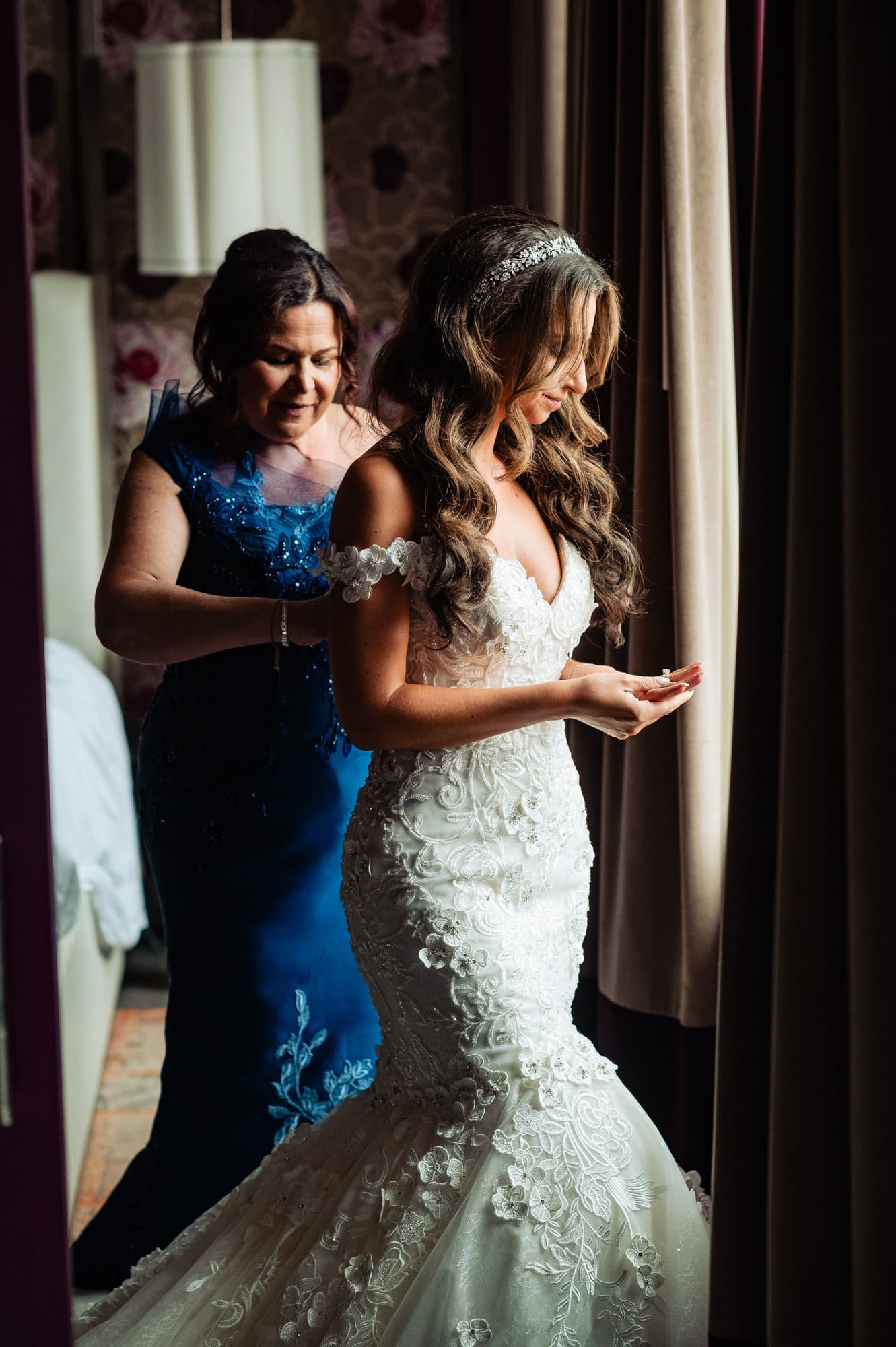 mother is checking her daughter's wedding gown