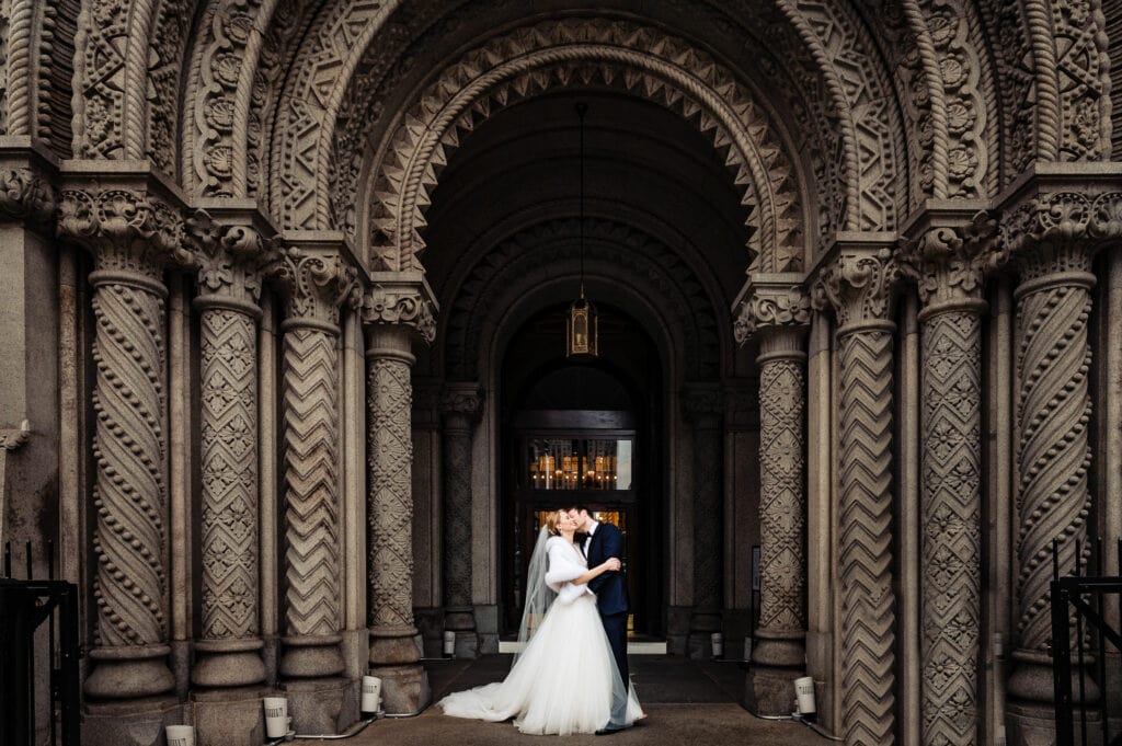 Bride and groom kissing in front of One North Broad in Pholadelphia