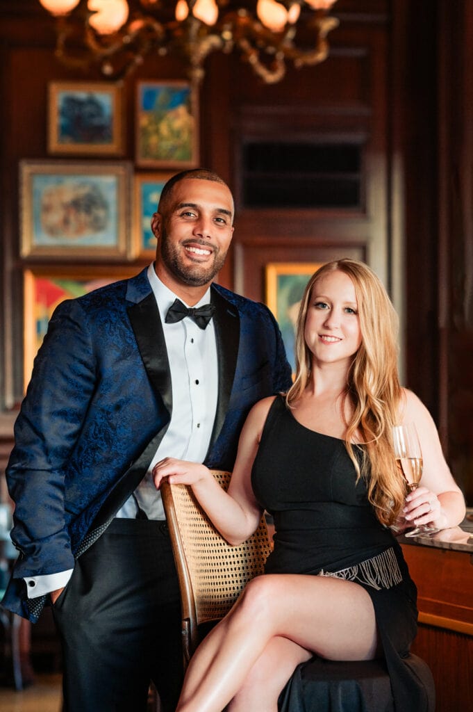 couple smiles at the camera while the girl is sitting at a bar counter