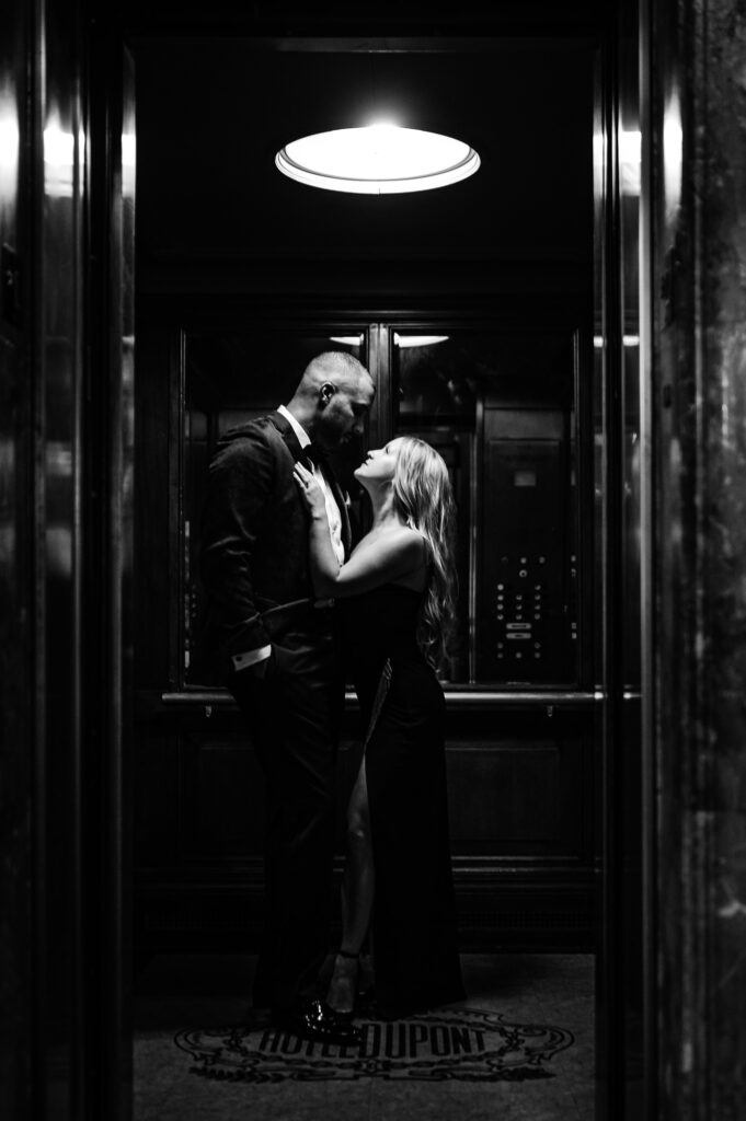 couple looks at each other lovingly in an elevator during their engagement shoot