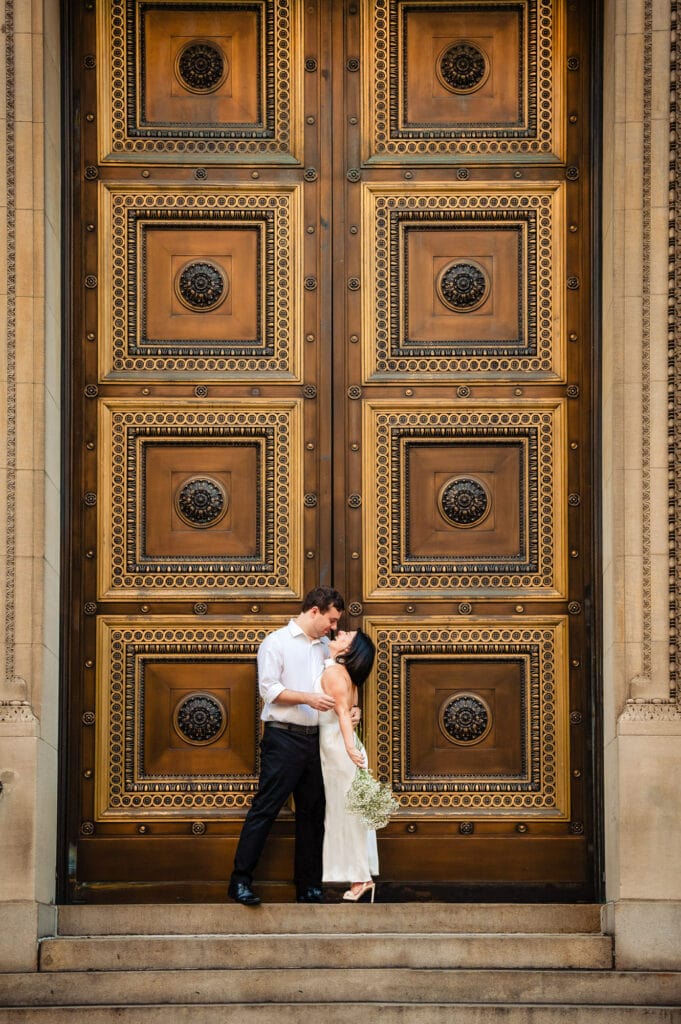 woman and man kissing eachother infront of the huge door