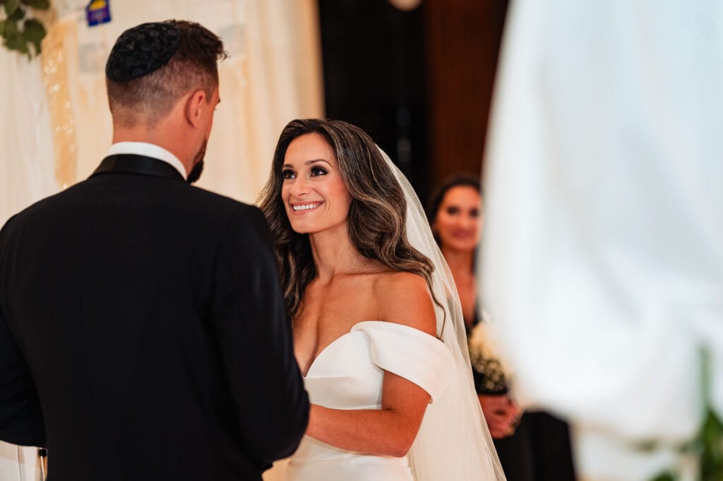 candid shot of the bride at the altar looking at the groom