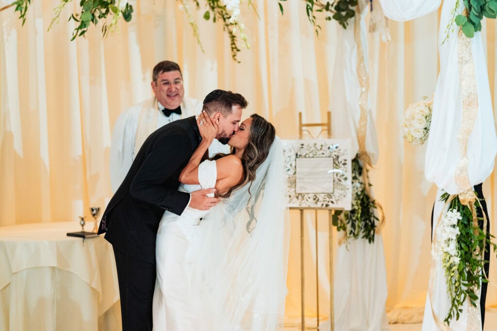 bride and groom kissing on the altar
