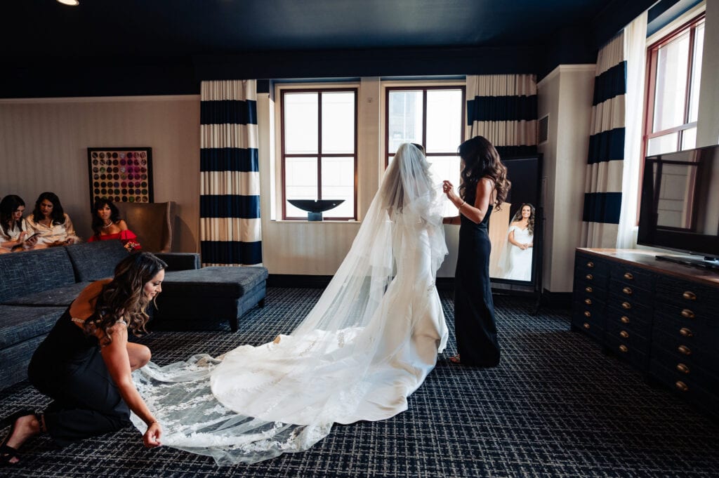 bride is getting help from her sisters prepping for the wedding