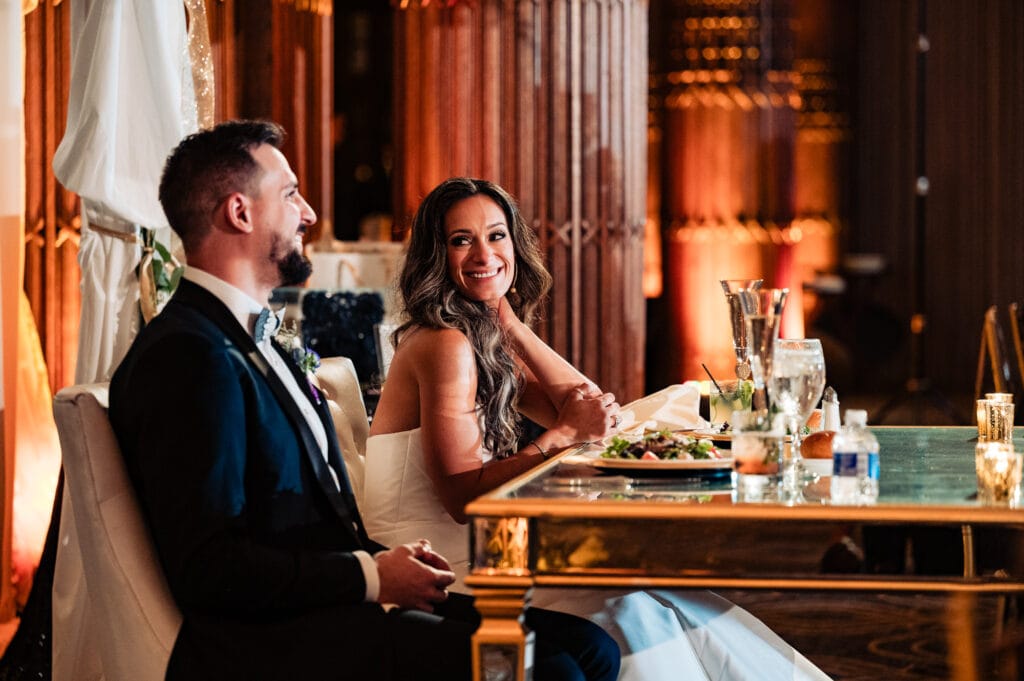 the newlyweds are all smiles at their sweetheart table