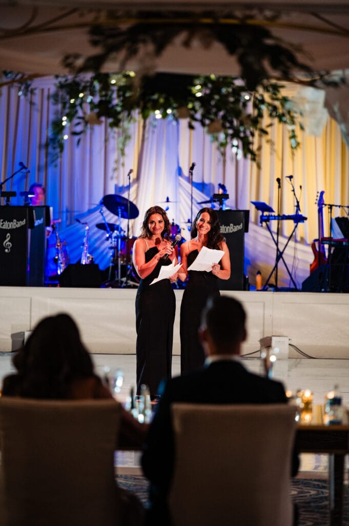two female guests share a speech during the wedding ceremony
