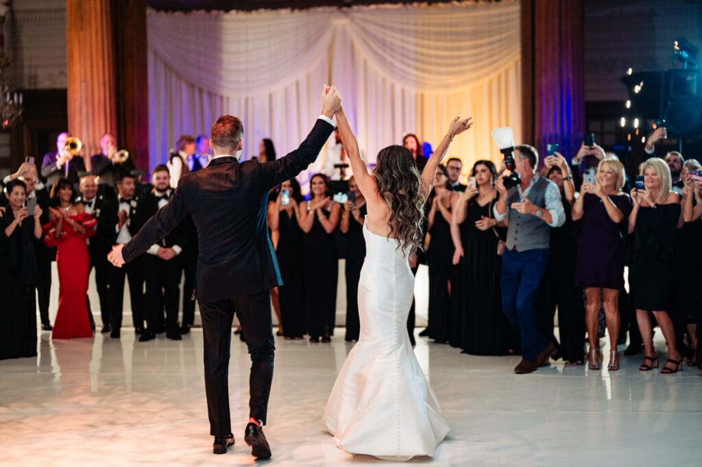 bride and groom cheering as newlyweds