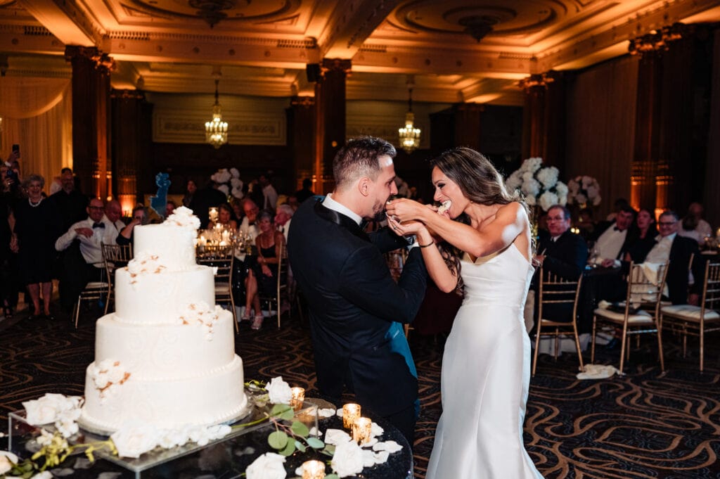 bride and groom feeding each other the wedding cake