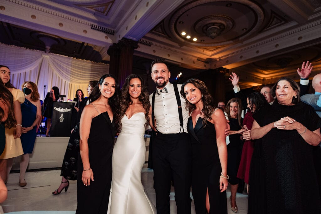the newlyweds poses for the camera along with their guests