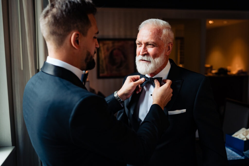 groom is fixing his father's tie