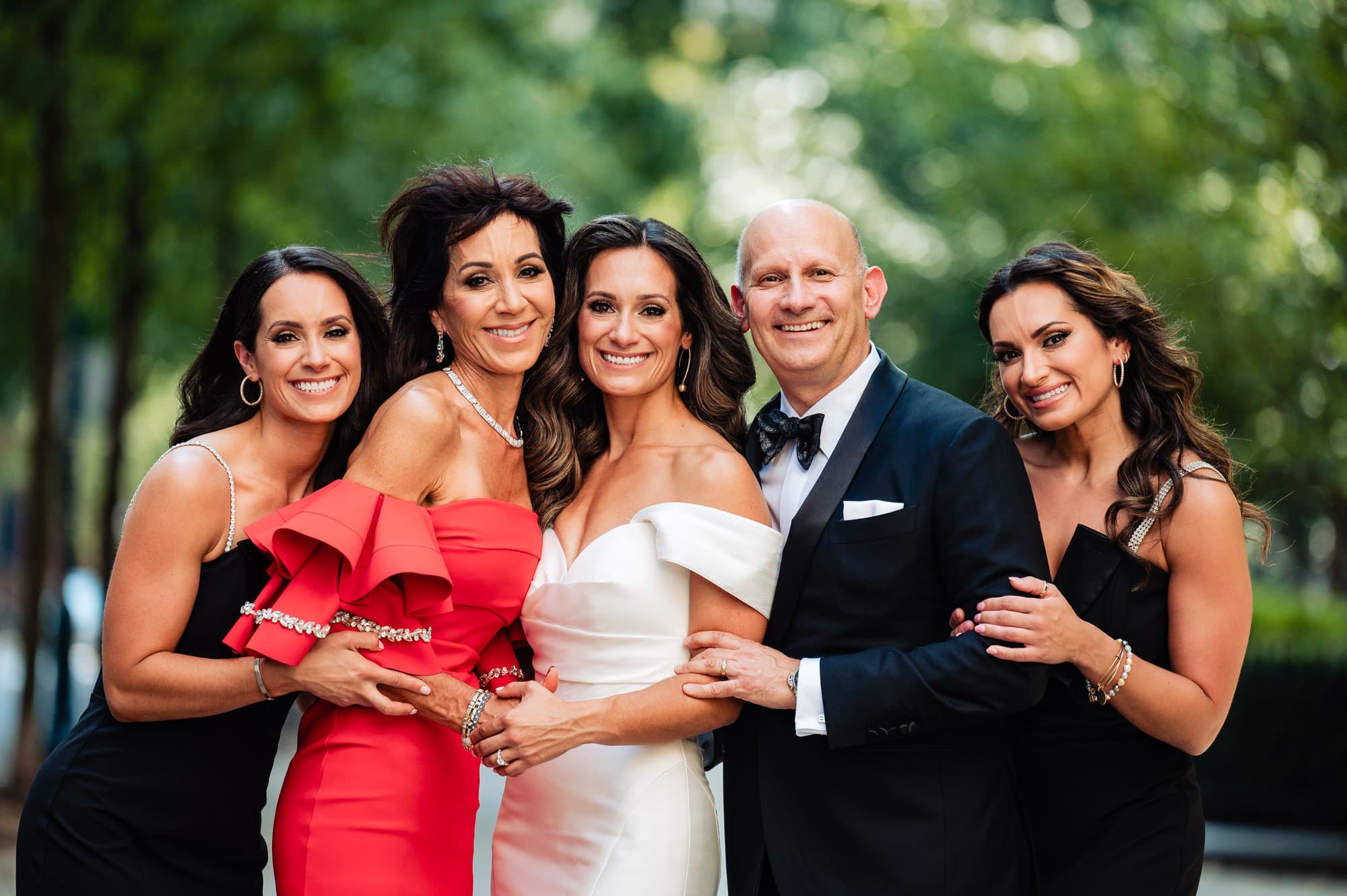 bride poses for the camera along her family