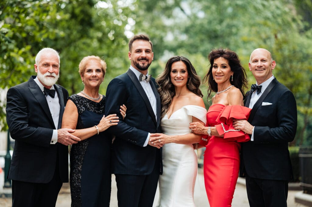 bride poses for the camera along her family