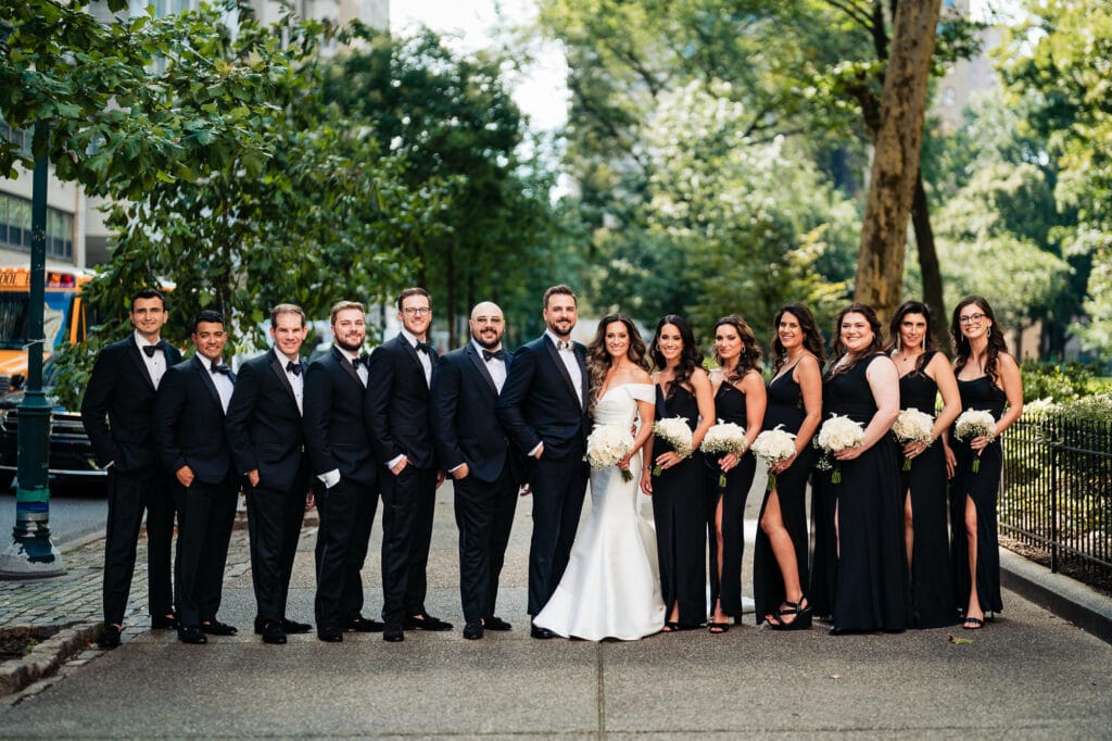 the bride and groom pose along with the entire bridal party