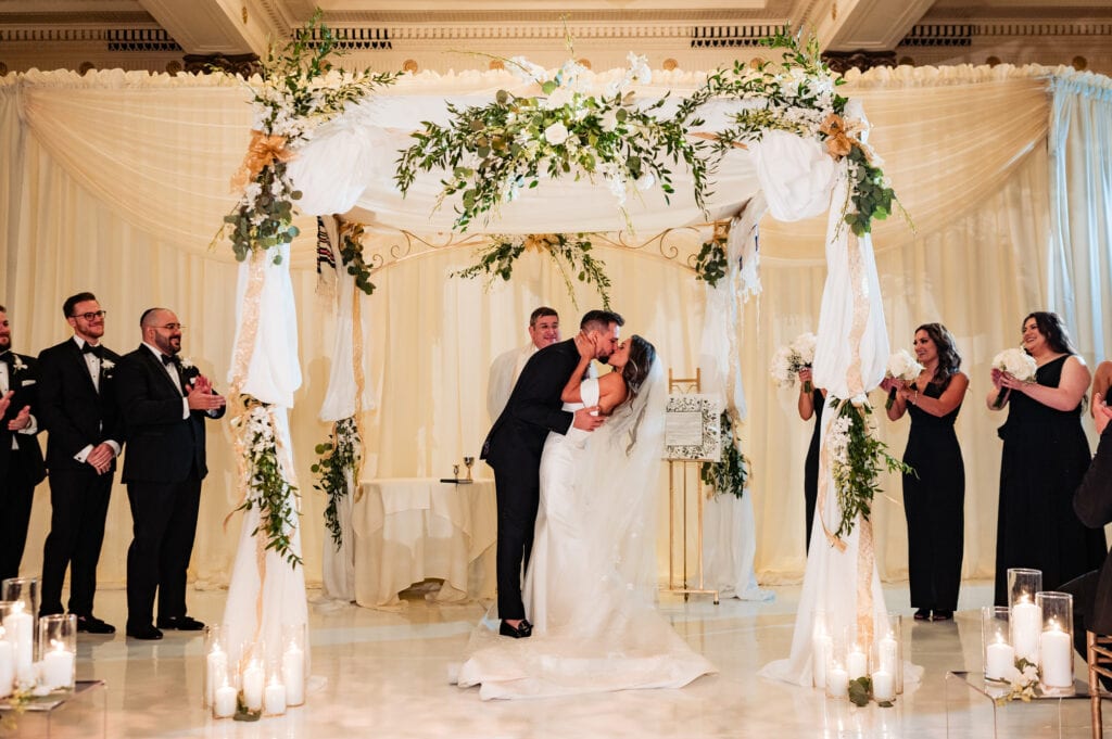the first kiss of the newlyweds under a chuppa