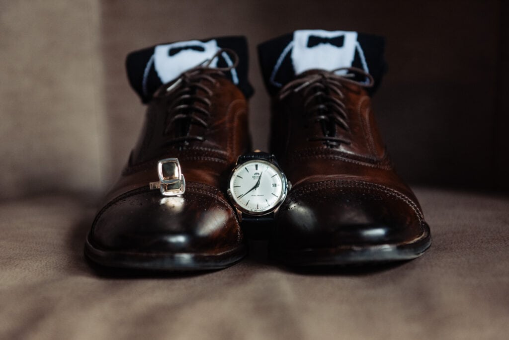groom's shoes and socks with his watch placed in between the shoes