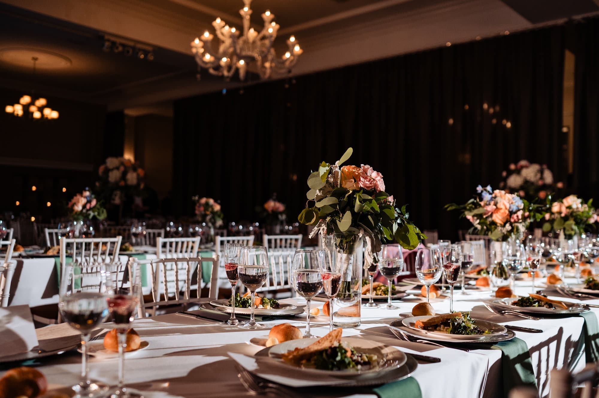 the wedding reception table arrangement of Vie by Cescaphe adorned with orange and white florals