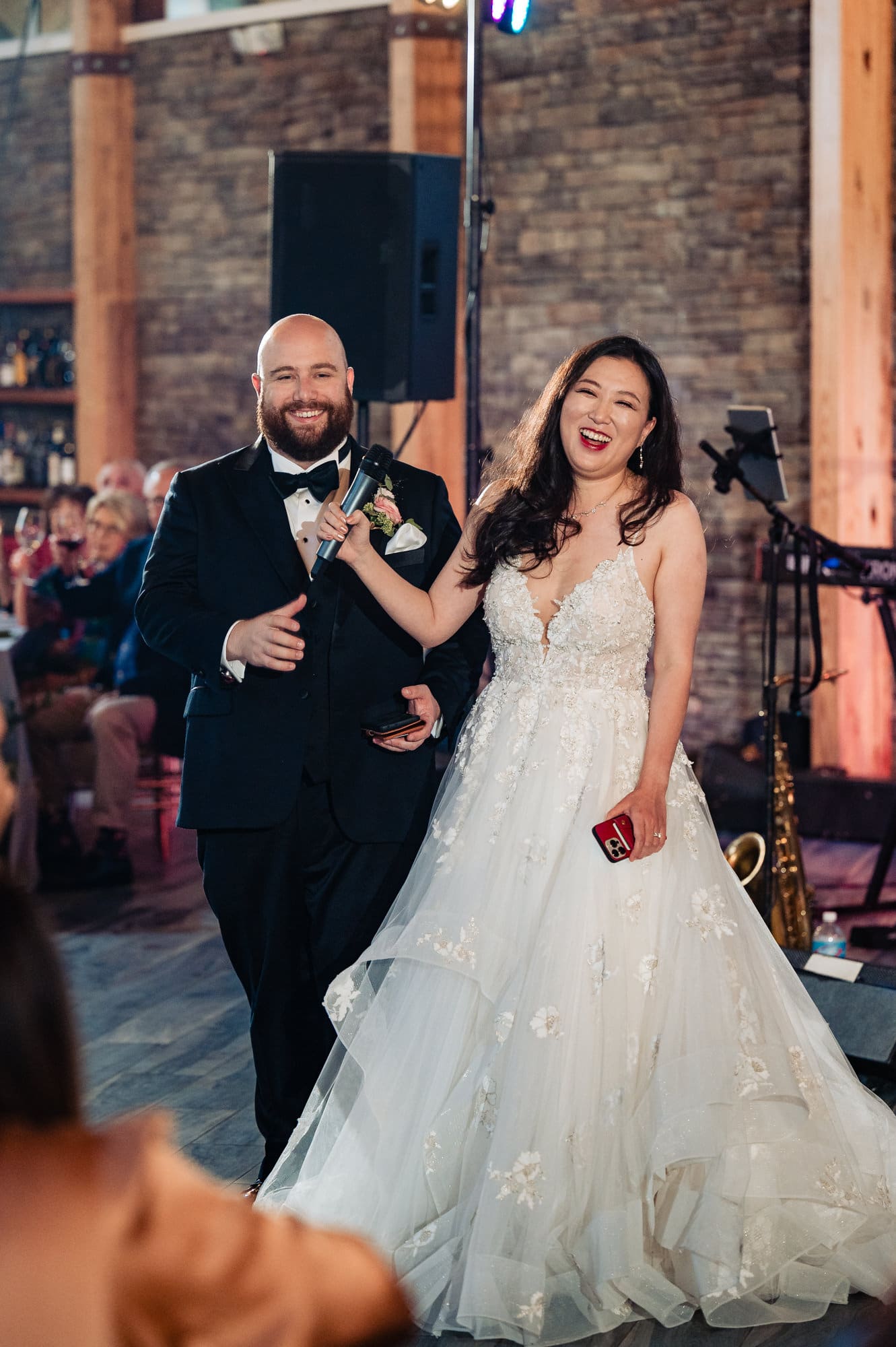 newlyweds are laughing during their wedding reception