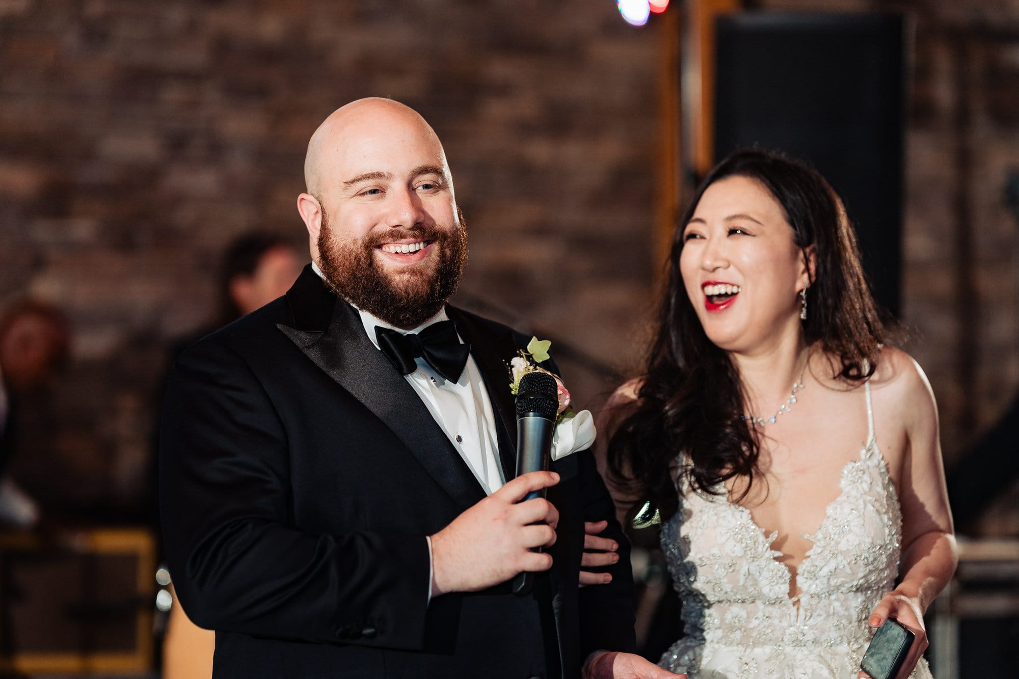 newlyweds are laughing their lungs out during their wedding reception