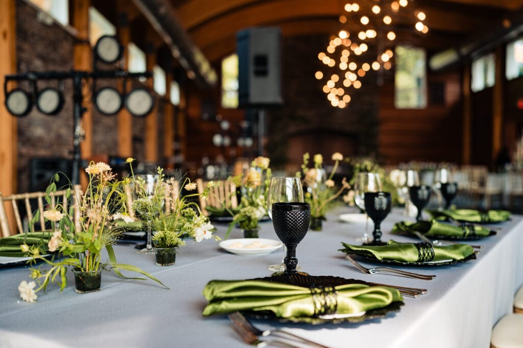 the wedding reception with tables covered in white cloth and green table napkins are placed on top of plates