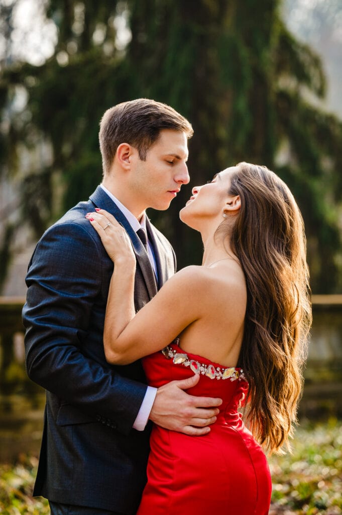 Captured amidst the vibrant fall shades of Winterthur garden, a loving couple gazes at each other tenderly, a stunning portrait echoing the beauty of the season.
