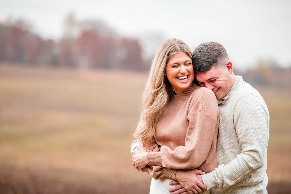 man and woman smiling as they embrace each other during their e shoot