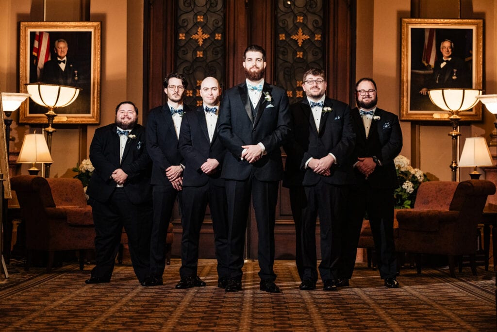 groom posing with his groomsmen for the camera