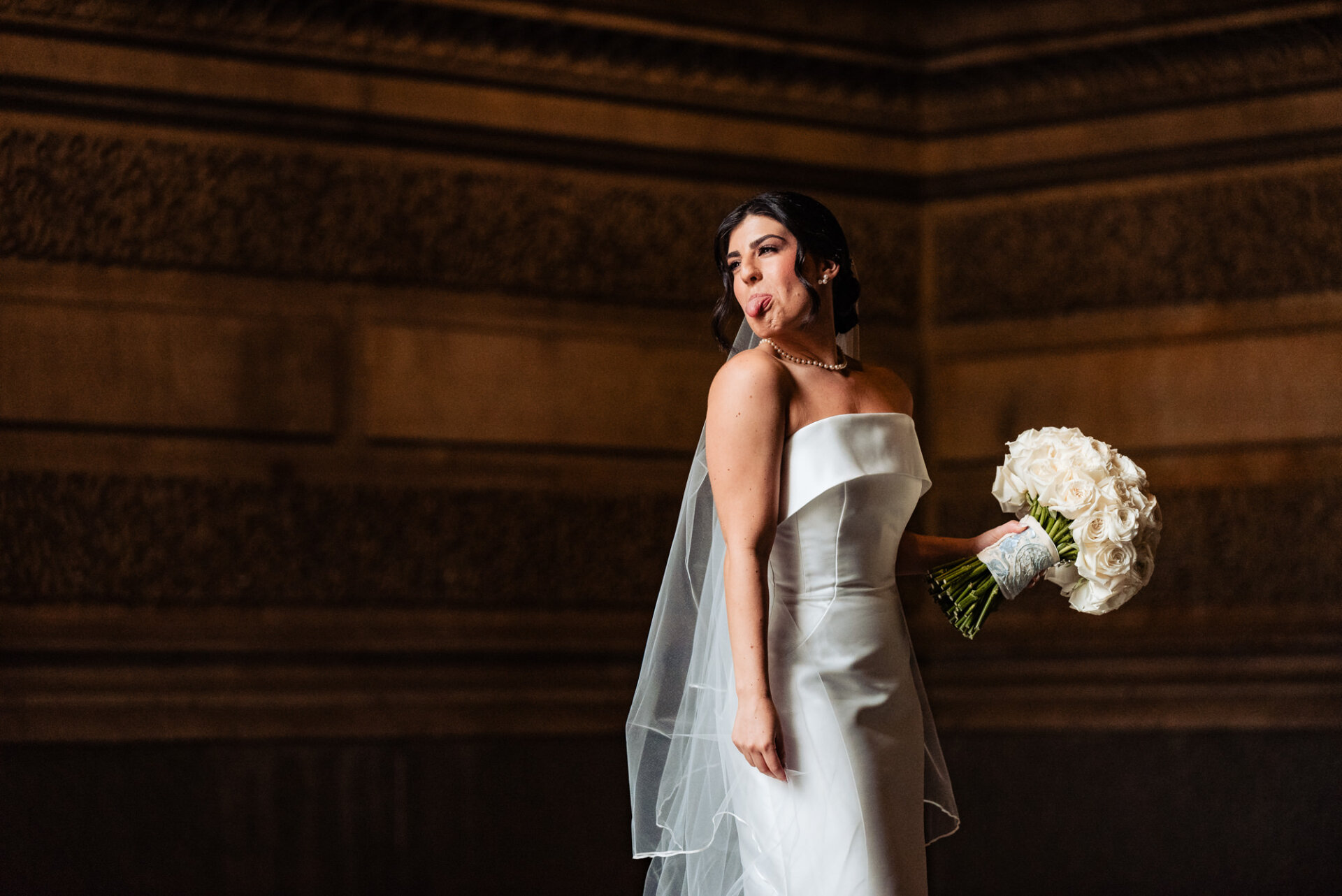 In a playful solo portrait, the bride strikes a charming pose with her tongue out, adding a touch of whimsy and spontaneity to her bridal photoshoot.