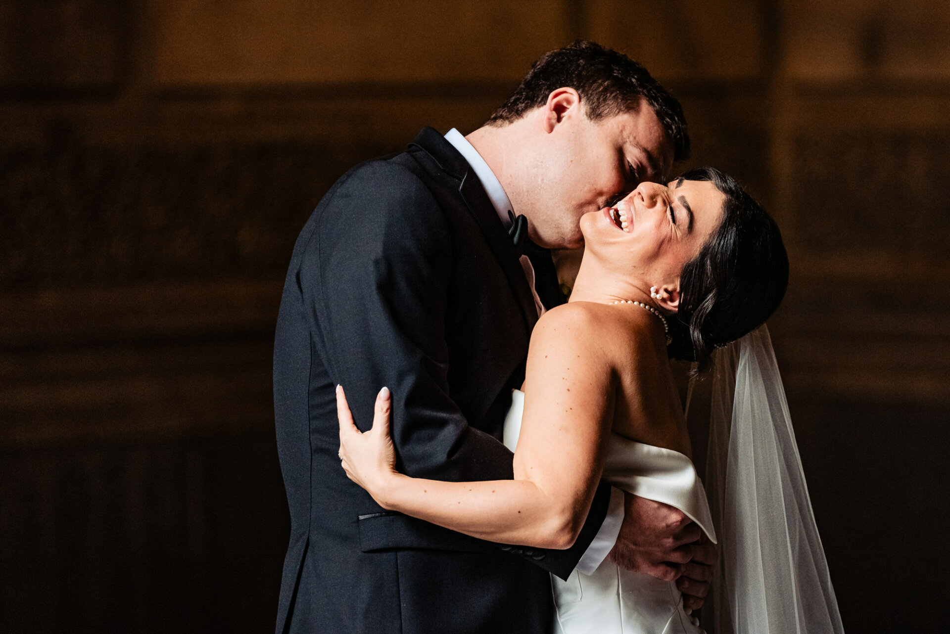 In their couple portrait, the bride and groom share warm smiles, their eyes locked in a moment of pure love and happiness, perfectly encapsulating the joy of their union on their wedding day.