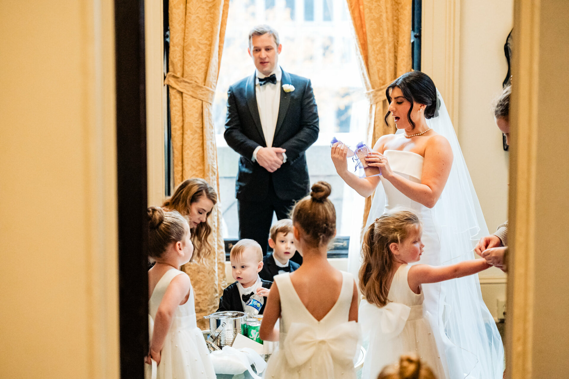 Surrounded by the innocence and sweetness of childhood, the bride is presented with a heartfelt gift from the little ones, their gestures of love and affection adding a precious touch to the moments leading up to her wedding day.
