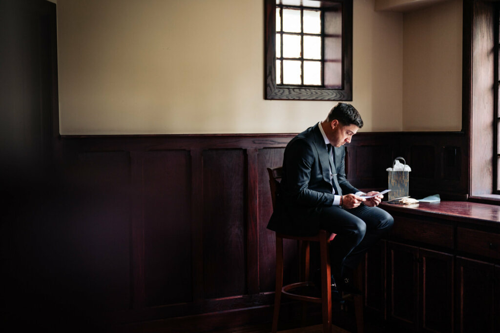 Groom reads a heartfelt letter from his bride, moments of quiet reflection before their wedding ceremony.
