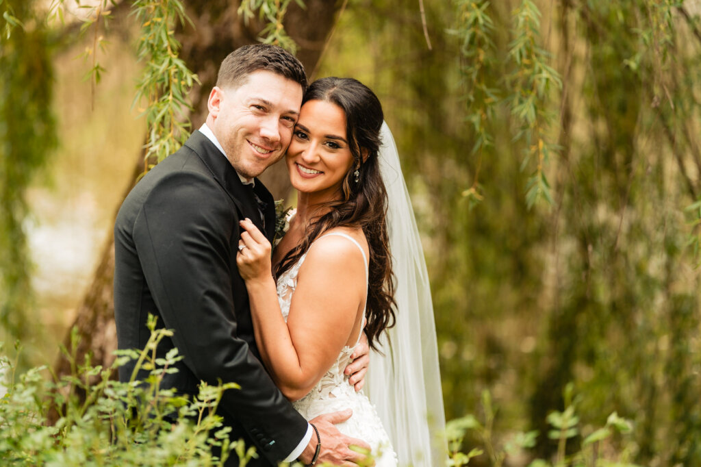 The bride and groom flash radiant smiles for the camera