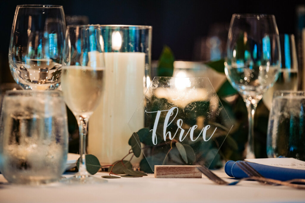 In a close-up shot, the table is adorned with a breathtaking display of fresh flowers, flickering candles casting a soft glow, meticulously arranged cutlery, and an elegant menu