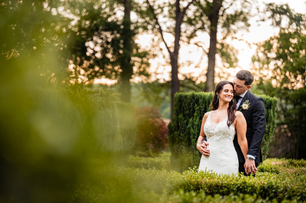 The groom envelops his bride in a tender embrace from behind