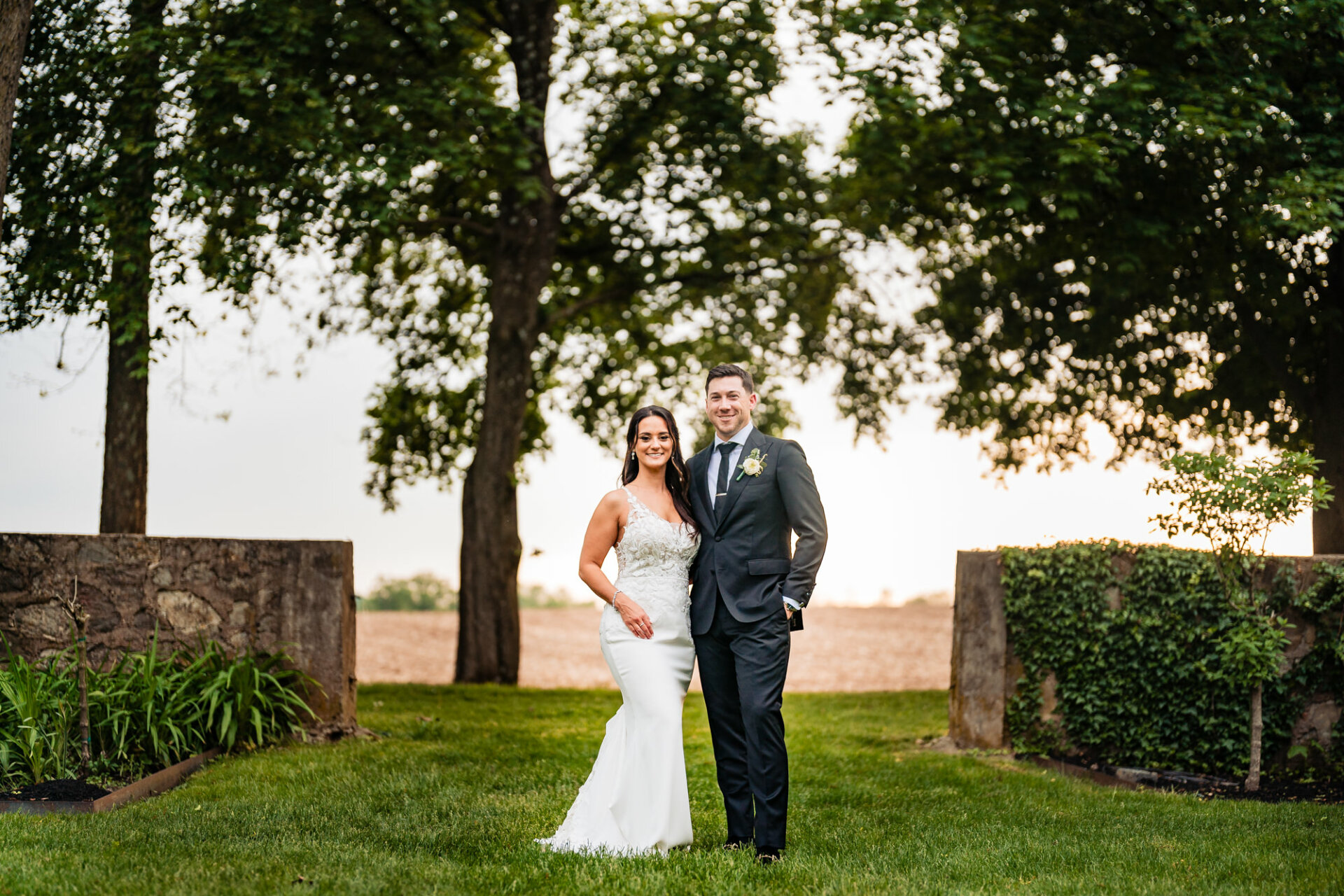 The groom and his bride pose for a captivating bridal portrait, surrounded by the tranquil beauty of the garden, their love illuminated by nature's splendor.