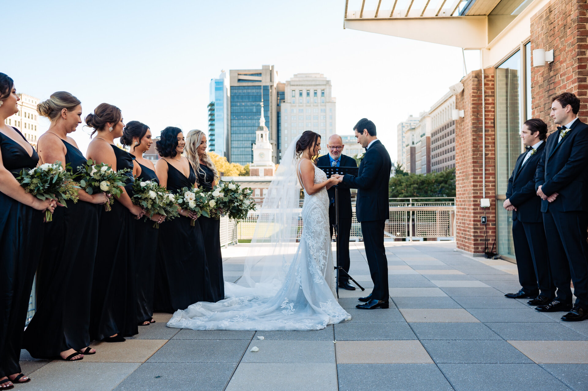 In a poignant moment during their wedding ceremony, the bride and groom exchange vows and place their wedding bands on each other's fingers, symbolizing their commitment and love.