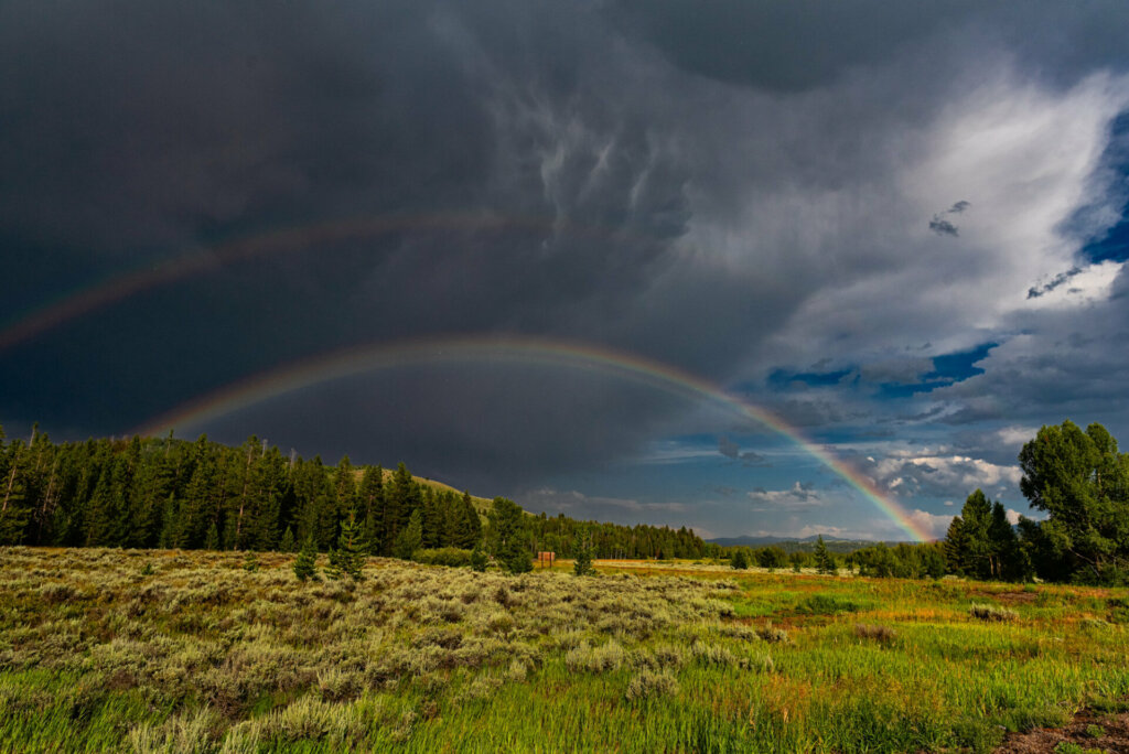 A spectacular double rainbow arcs across the sky above the Grand Tetons
