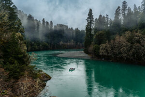 As you stand along the banks of the Smith River, you're greeted by a mesmerizing sight: the tranquil waters of the river shimmer with hues of blue and green, creating a stunning contrast against the surrounding landscape.
