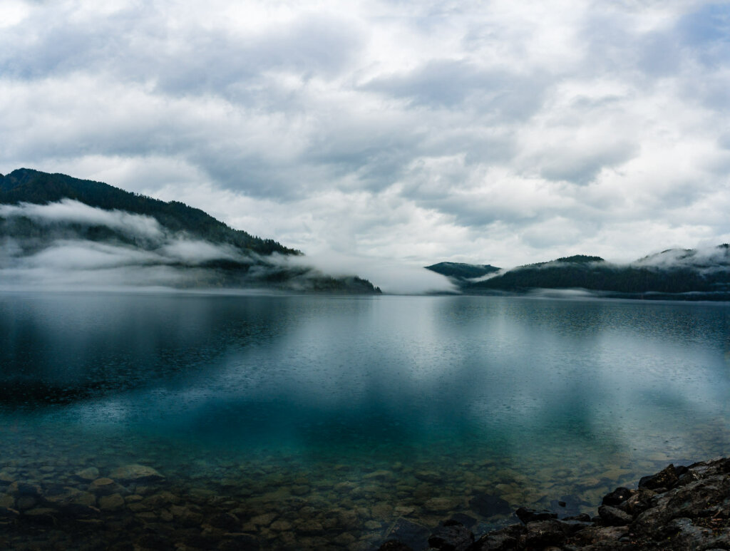 Lake Crescent, a pristine gem nestled within Olympic National Park, showcasing crystal-clear waters surrounded by majestic mountains and lush forests