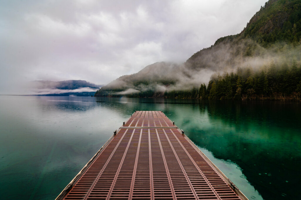 A wooden dock extending into the pristine waters of Lake Crescent, framed by the majestic beauty of Olympic National Park.
