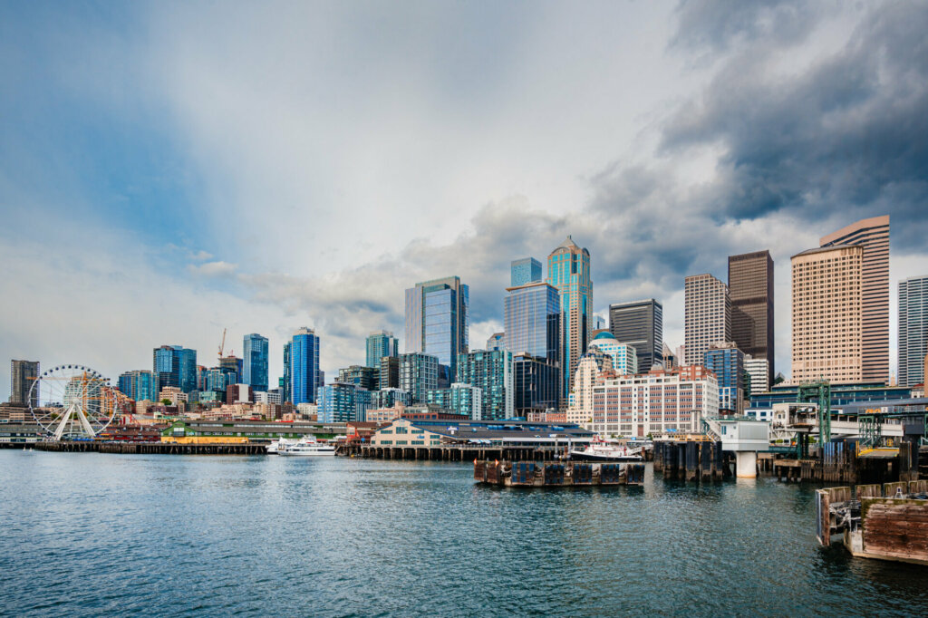 A panoramic view of downtown Seattle captured from the water, showcasing the city's iconic skyline, with towering skyscrapers, bustling waterfront, and the majestic Puget Sound in the foreground.