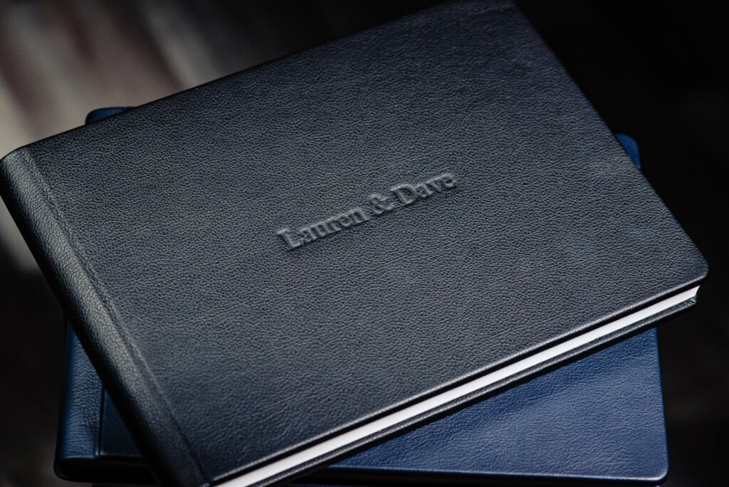 A classic wedding album bound in a rich royal blue leather cover. The luxurious deep blue tone gives it an elegant, timeless look. The leather appears smooth and supple to the touch, conveying a premium, heirloom-quality feel.