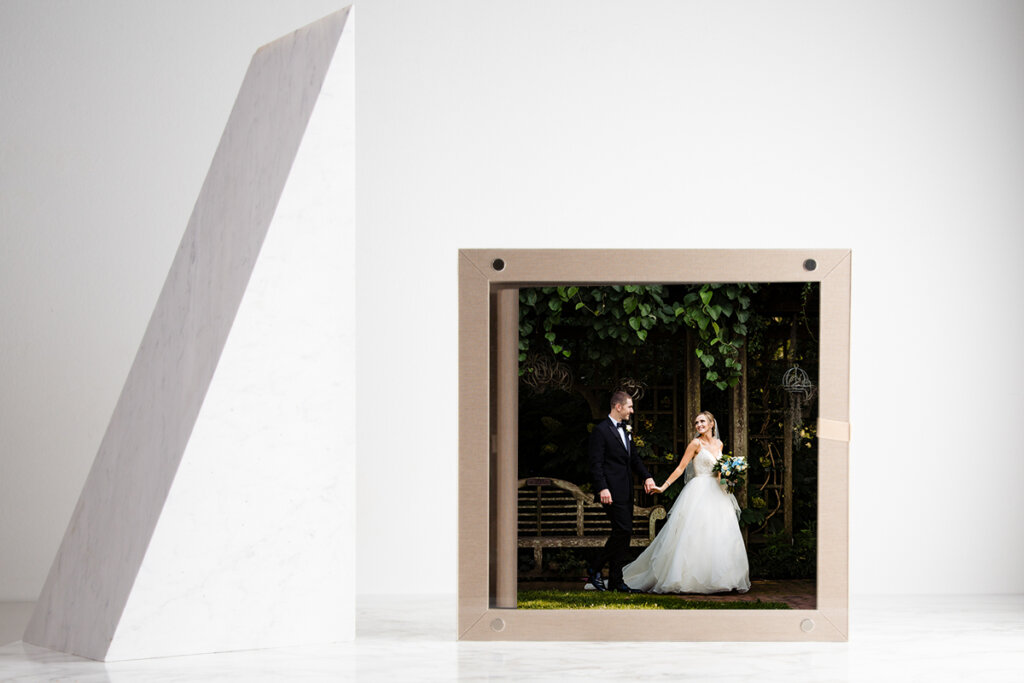 A wedding album with a classic, elegant design. The cover features a photo from the wedding day and is framed by a decorative border in rich heritage color