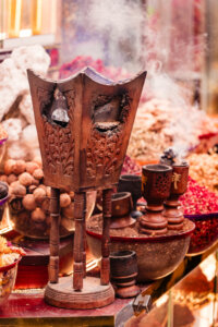 a wooden incense burner beside a display of colorful spice in Fahidi District