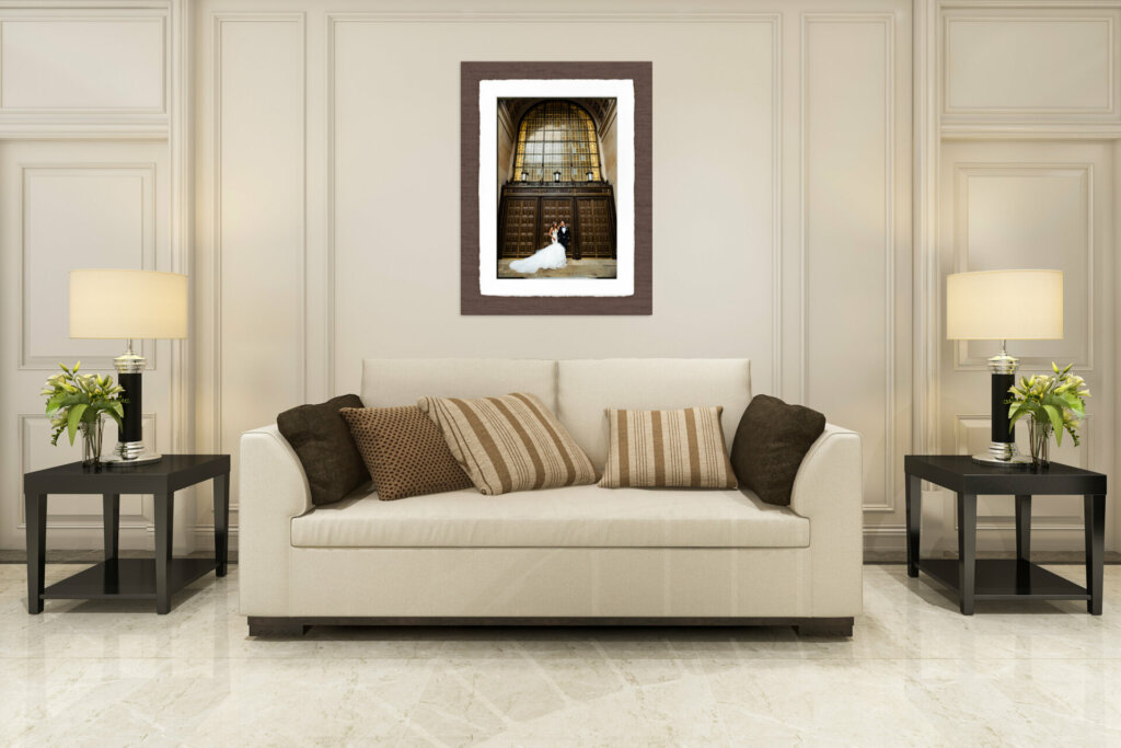 A spacious living room with a large framed wedding portrait hanging prominently above a comfortable couch