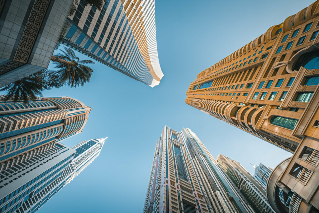 low angle shot of the Modern glass skyscrapers in Dubai with blue sky in background.