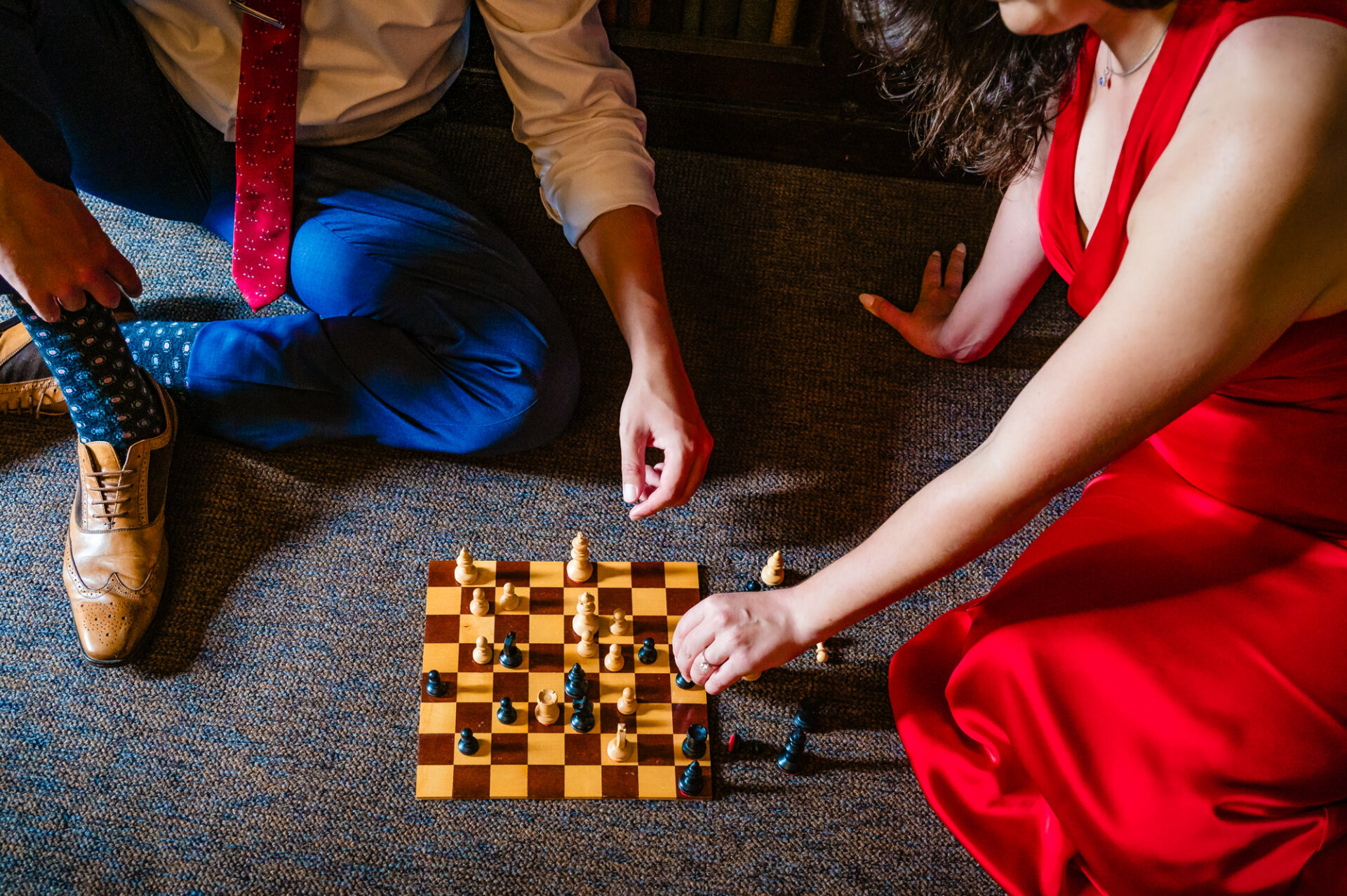 Capturing a sweet scene as a couple sits close on the comfy carpet of Carpenter's Hall library for their engagement photos.