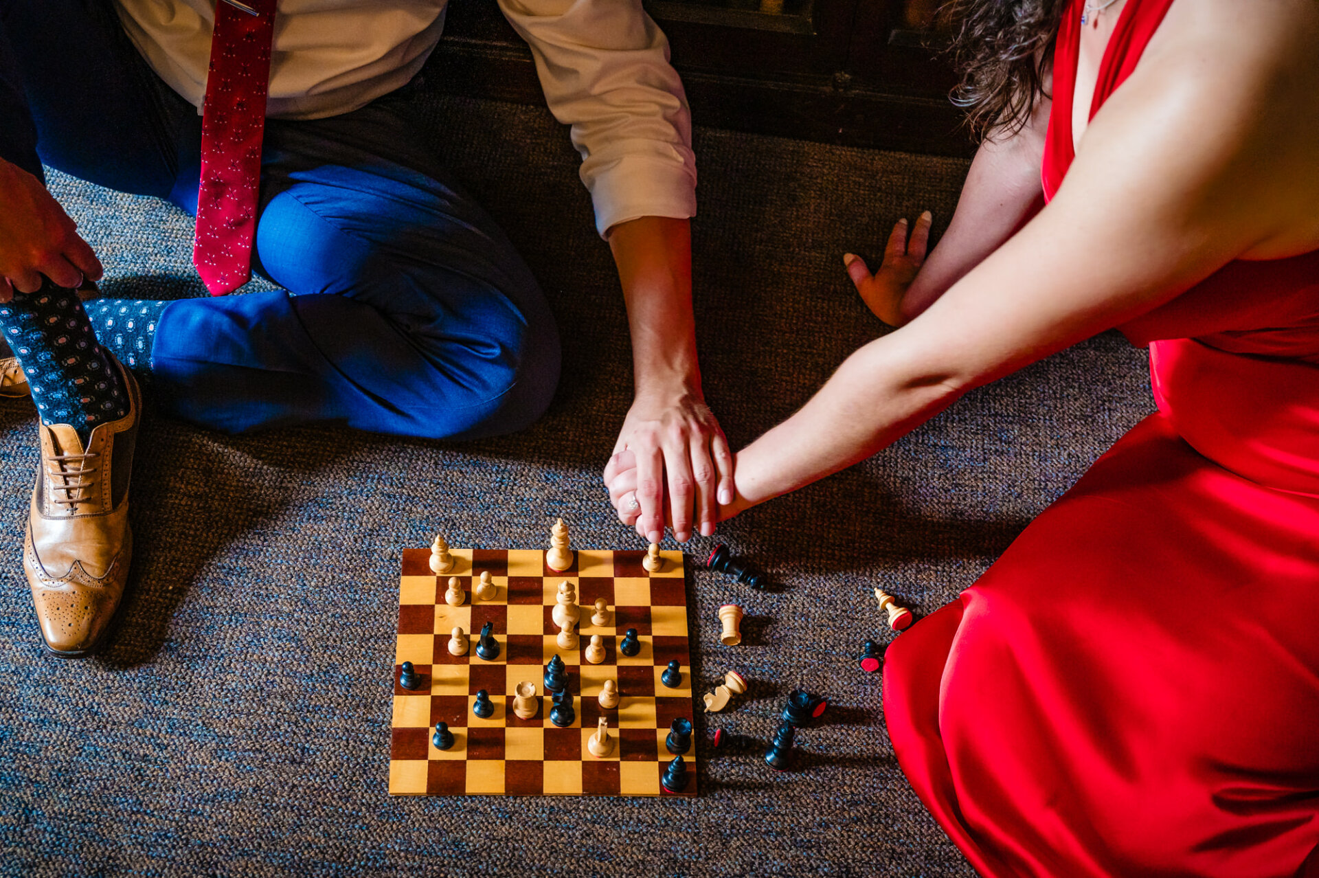 A couple, bathed in warm light, sits nestled together in Carpenter's Hall's historic library, capturing a moment of love during their engagement shoot.